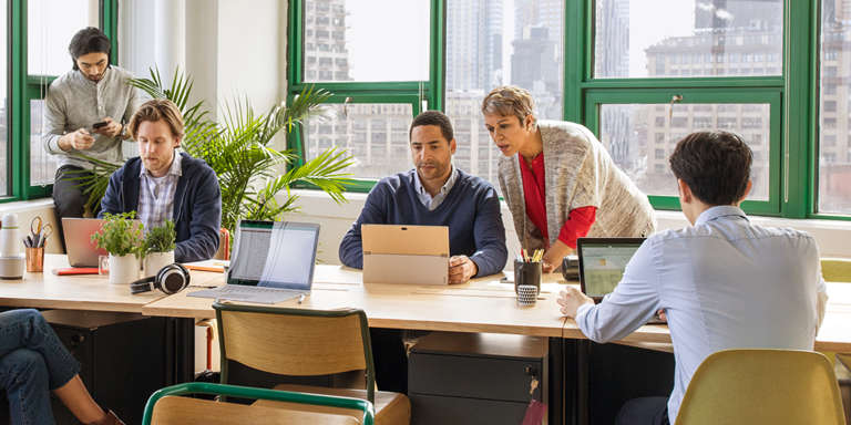 A group of people sitting at a table in front of a window